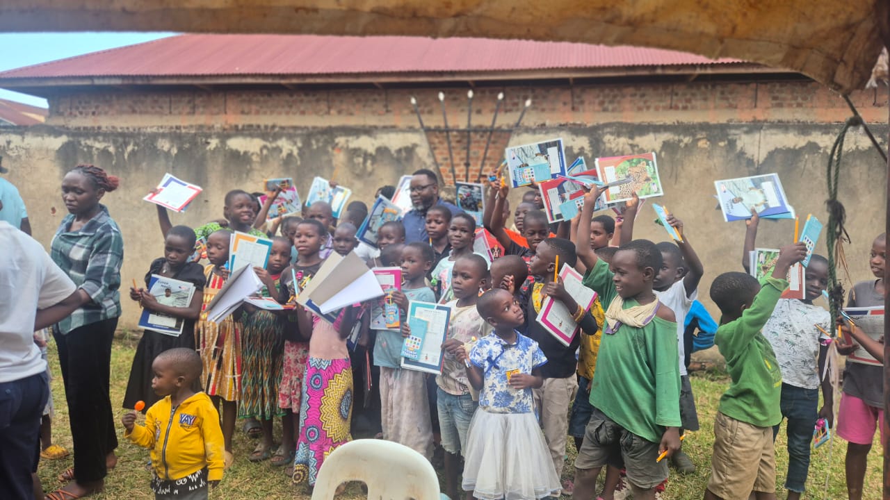 Children holding educational supplies received through Seeds of Destiny USA
